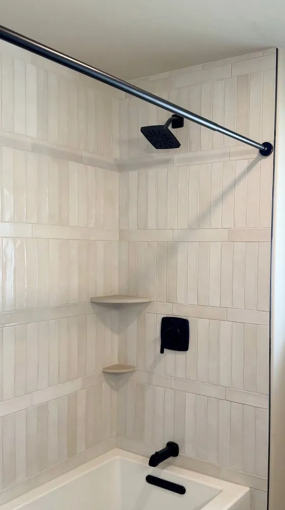 Tub surround in cream vertical stacked tile with matte black fixtures