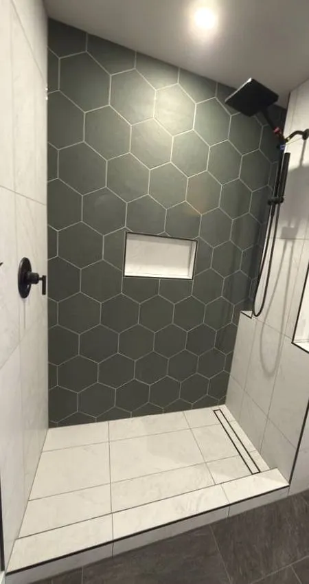 Green hexagon feature wall in a custom shower with a linear drain