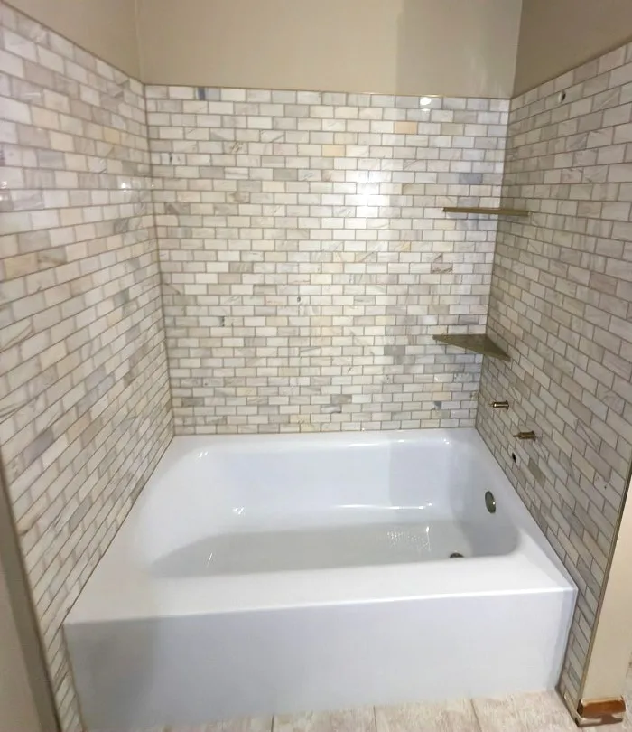 The full tub surround in marble subway tile
