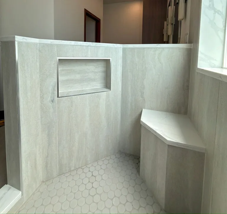 Shower with a corner bench, recessed niche and penny tile floor