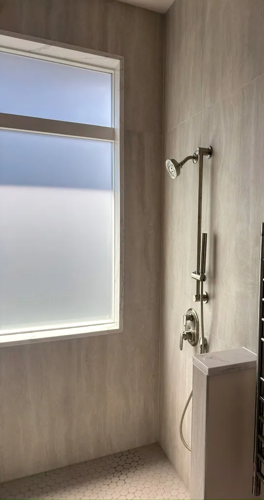 Shower fixtures with a heated towel rack outside the enclosure